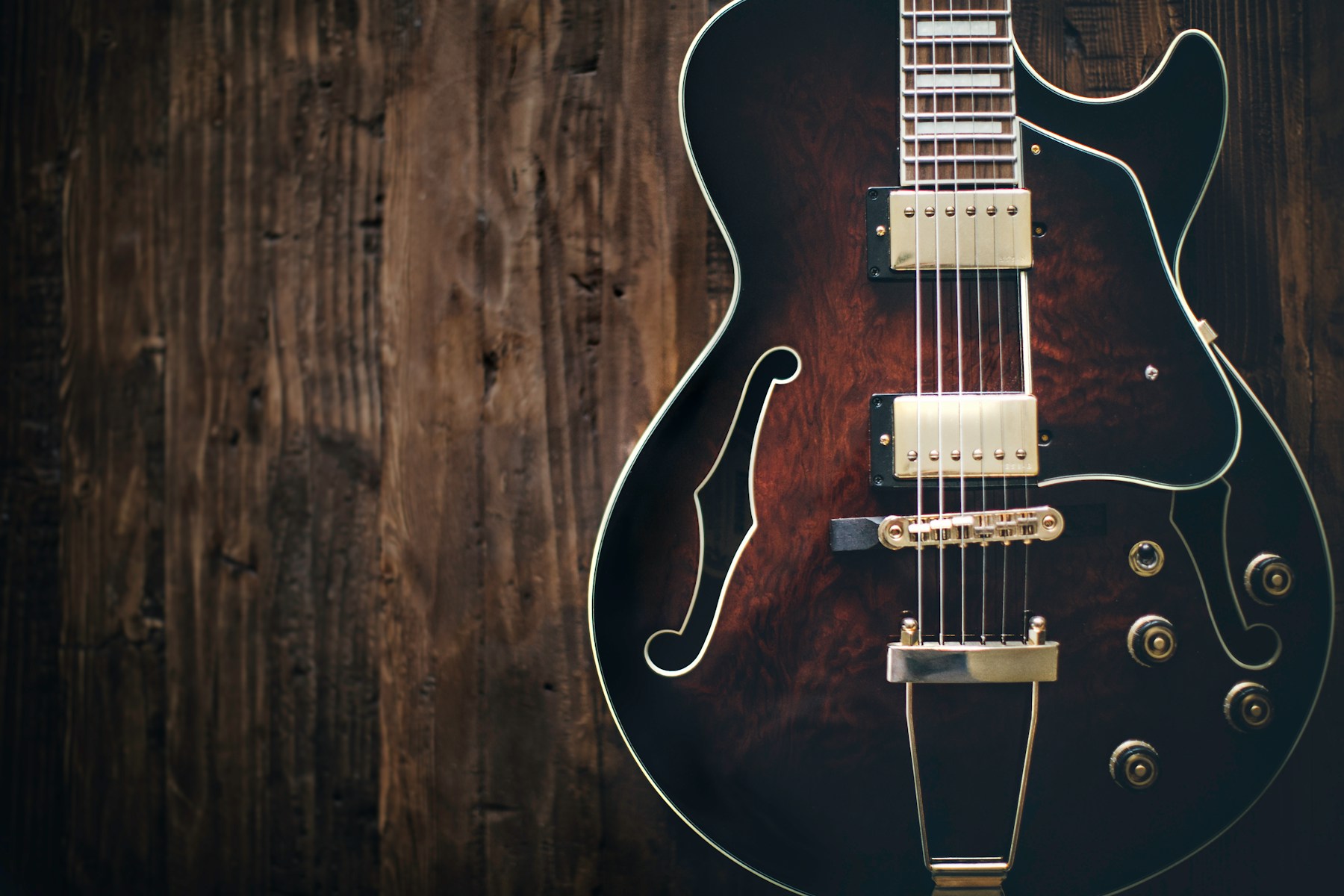 Electric guitar resting on a wooden surface in warm natural light